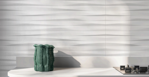 Aurelia sculpted white ceramic tile 300 × 600 mm with raised linear wave texture in a contemporary bathroom setting.